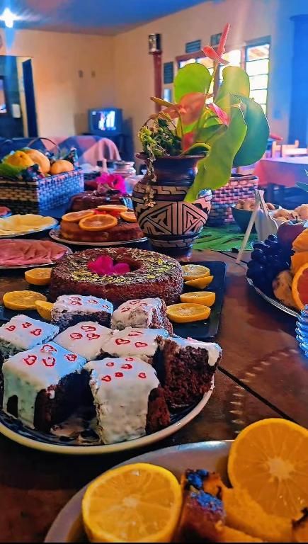 Mesa de café com bolos, laranjas e frutas
